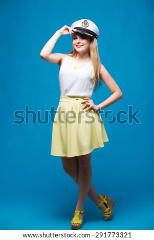 beautiful girl in the studio on a blue background in the style of pin-up, in a yellow dress, Dresses captain cap,\
Â  flirts