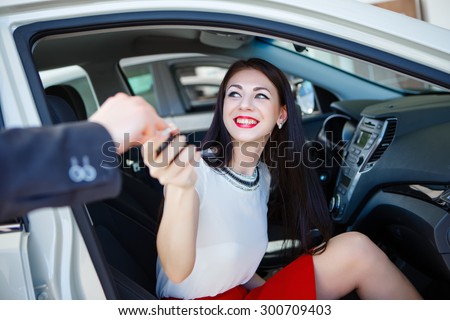 businesswoman receiving keys of her new status car from dealer