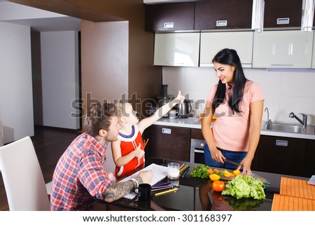 little girl cutting vegetables with her mother in the kitchen, stylish people, hipsters