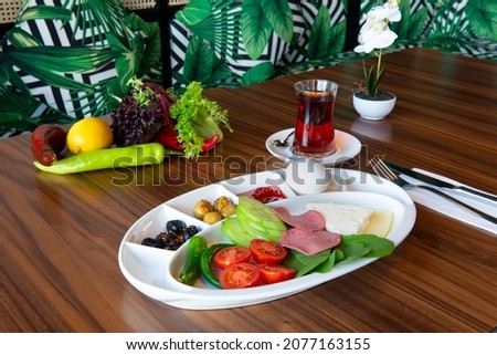 Turkish breakfast traditional , Wood table, Turkish Tea ,tomato salad, black and green olive
