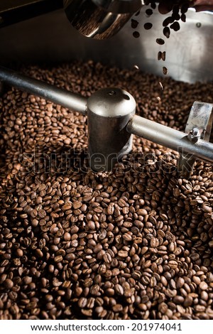 The freshly roasted coffee beans from a coffee roaster are mixing in the cooling cylinder.