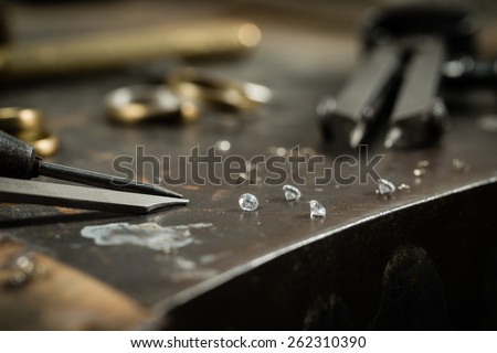 Working desk for craft jewelery making with professional tools. Still life of goldsmith\'s tools with diamonds. Macro shot.