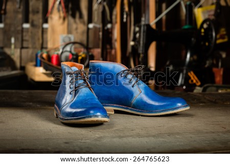 A pair of men's leather shoes in the shoemaker's workshop on working desk.