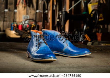 A pair of men\'s leather shoes in the shoemaker\'s workshop on working desk.