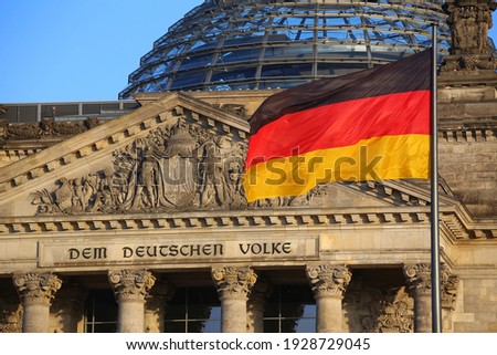The German flag in front of the Reichstag building in Berlin. The inscription says: Dem Deutschen Volke - To the German people. Foto stock © 