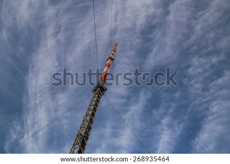Red and white radio tower in unusual angle