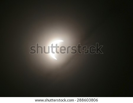 HDR shot of solar eclipse on March 20, 2015 in Germany, with cloud silhouettes.