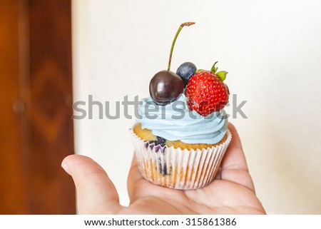 Blueberry cupcakes with blue cream and berries