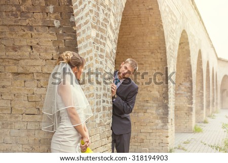 Bride and groom fooling around in the arches of the ancient fortress