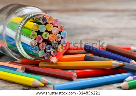 Colorful pencil crayons on wooden background