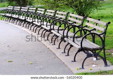 Benches by a half-round in park. Nobody is present