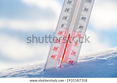 The thermometer lies on the snow in winter showing a negative temperature.Meteorological conditions in a harsh climate in winter with low air and ambient temperatures.Freeze in wintertime.Sunny winter Foto stock © 