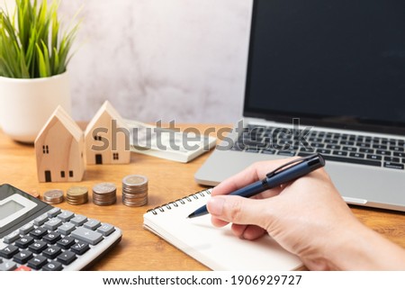 Hand holding pan with stacking Coins and wooden house model or real estate concept. Real estate broker. insurance or loan real estate. business house investment idea.