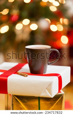 Gift box and cup of coffee with christmas decoration on background