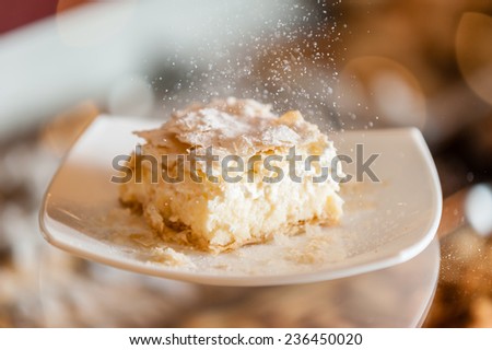 A fresh piece of coconut vanilla cream cake on a white plate