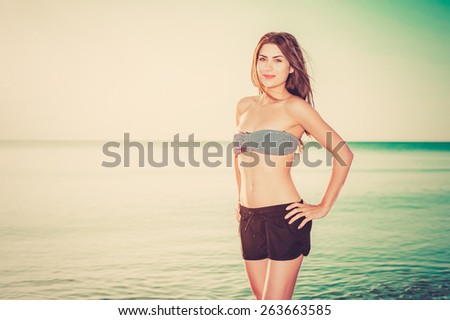 Happy sunshine woman. Girl smiling friendly looking at camera on sunny summer day under the hot sun on beach.
