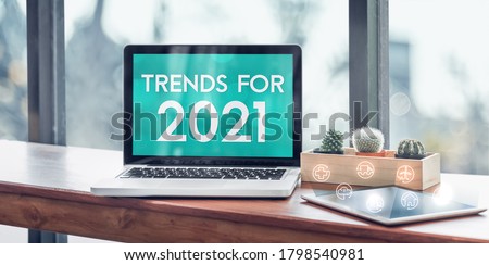 Trends for 2021 in laptop computer screen with icon floating on tablet on wood stood table in at window with blur background,Digital Business or marketing trending Foto d'archivio © 