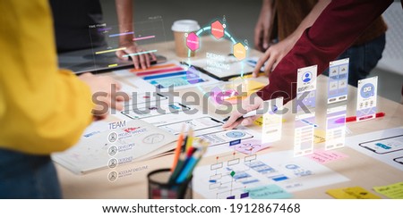Close up ux developer and ui designer use augmented reality brainstorming about mobile app interface wireframe design on desk at modern office.Creative digital development agency