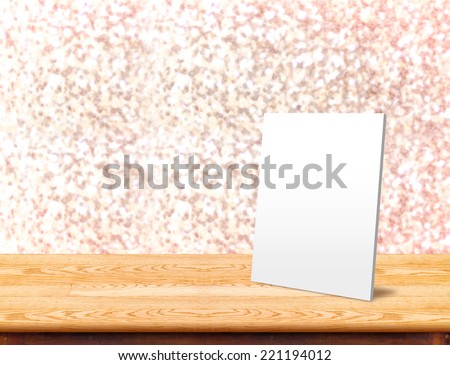 White paper frame at Wood Table with bokeh pink sparkling background,Empty room for display your product