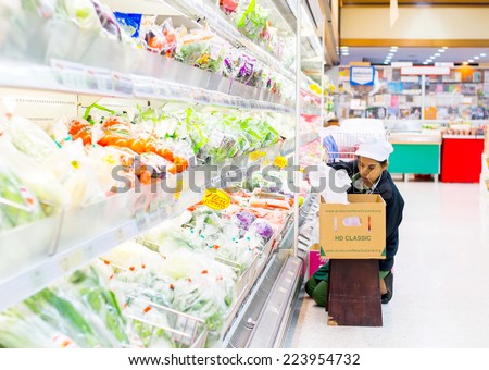 Bangkok ,Thailand-August 30 : Woman officer puts in order of Fresh vegetable into product shelf on 30 August 2014 at Foodland supermarket store, Bangkok, Thailand.