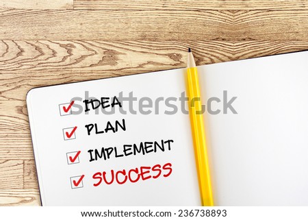 Open blank notebook with yellow pencil and success check box on wooden table,business concept