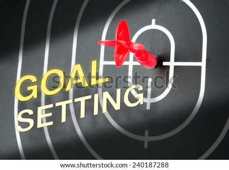 red arrow shooting at center of black dart board with word \