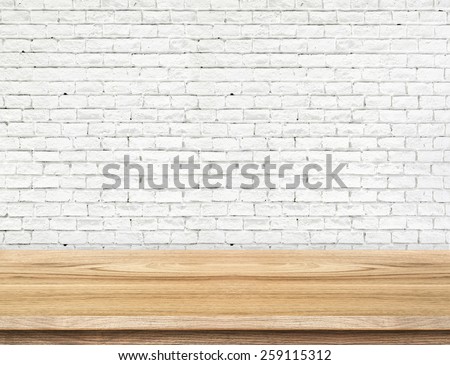 Empty wood table and white brick wall in background. product display template