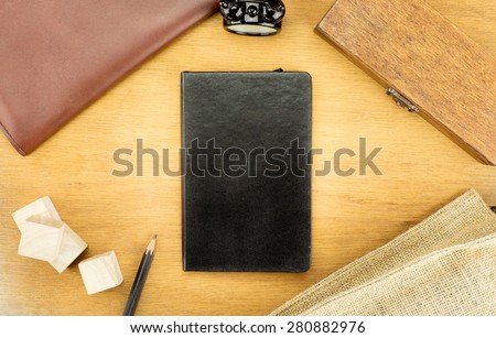 Wooden Table top with  clock,box,notebook,leather bag and pencil, Template mock up for adding your word on black book