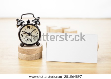 Blank Business card mock up and black alarm clock on light wooden table, Business corporate identity, Clipping path on business card
