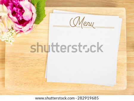 Top view of Blank wooden plate with white menu card and flower pot on table top,Mock up for adding your design, Clipping path on paper card.