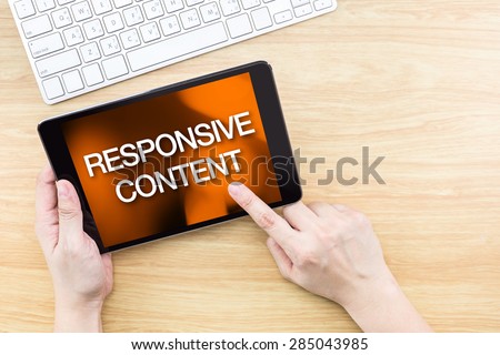 Finger click screen with Responsive content word with keyboard on wooden table,Website design concept