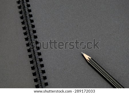 Close up at black pencil on blank black notebook,mock up for adding your content