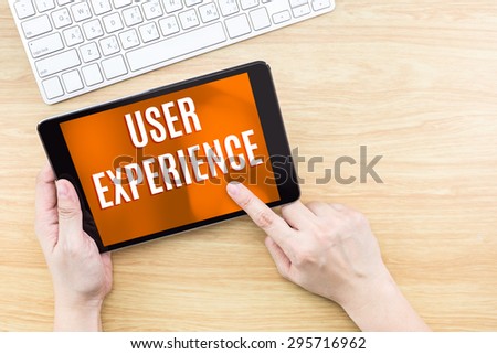 Finger click screen with User experience word with keyboard on wooden table,Digital Technology concept