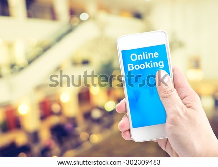 Hand holding mobile with online booking with blur background, Digital Booking concept.