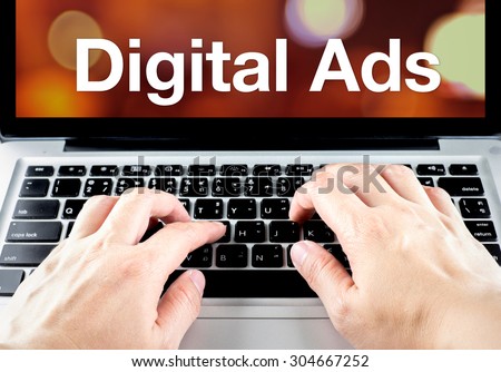 Digital ads word on laptop screen with hand type on keyboard, Digital Advertising concept.