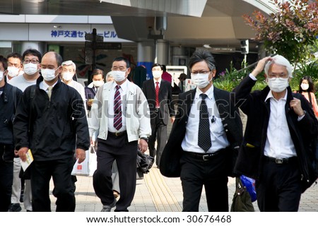 KOBE, JAPAN - MAY 20: People on the street wear face masks because of the outbreak of swine flu near Sannomiya JR station May 20, 2009 Kobe.