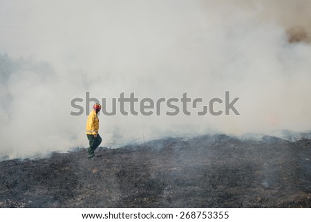 BOYARKA, UKRAINE - 27 MAR 2015: Firefighter on agriculture land after fire. It was demonstration training of forest fire fighters on suppression of surface fire on forest research station in Ukraine.