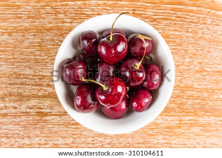 cherry on wooden table with water drop