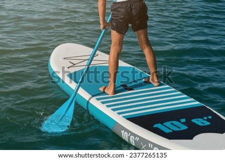 Image, Stock Photo Crop surfer on board in sea water