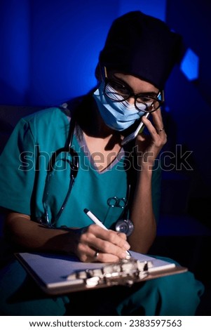 Image, Stock Photo Doctor making a phone call. Hospital staff working at night duty. Woman wearing uniform, cap and face mask to prevent virus infection