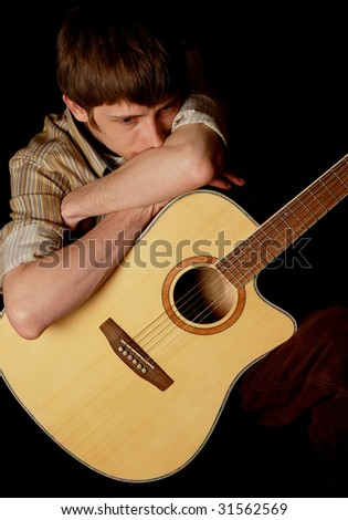 young musician playing guitar isolated on black