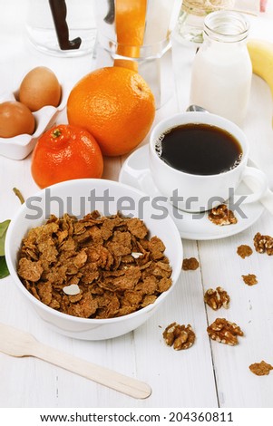 Breakfast with muesli, coffee and fruits over white wooden background