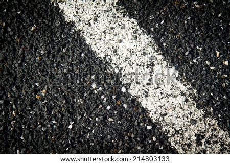 black asphalt texture background with white dashed line. close up