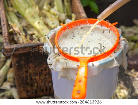 pours sugar cane juice produced from pressing sugar cane