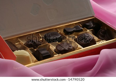 box of chocolate sweets on pink background