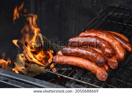Delicious sausages on the grill, ingredients, homemade meal, dish, food, fat, grass, high caloric, fire, fireplace, wood, gas oven, crispy, pepper, hungarian, smoke, baking, pepperoni, burnt, spicy  Foto stock © 