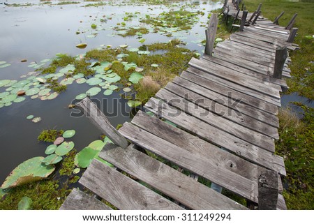 Old unfinished wood bridge over water