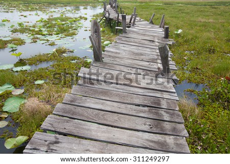 Old unfinished wood bridge over water