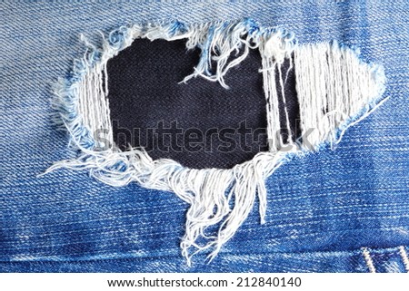Blue denim jeans in dark color tear up surface condition present the old damaging fabric damaged detail of texture background.