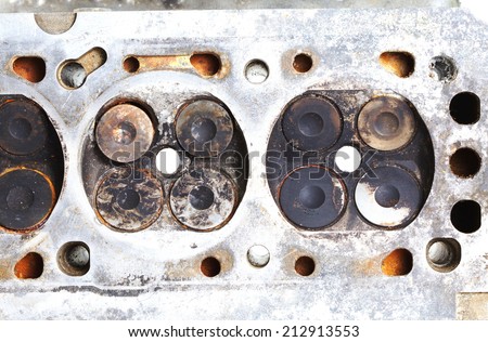 old and used vintage cylinder block made from aluminum alloy material present in the scene present the detail of valve of gasoline engine and damaged surface from carbon stain and rust stain.